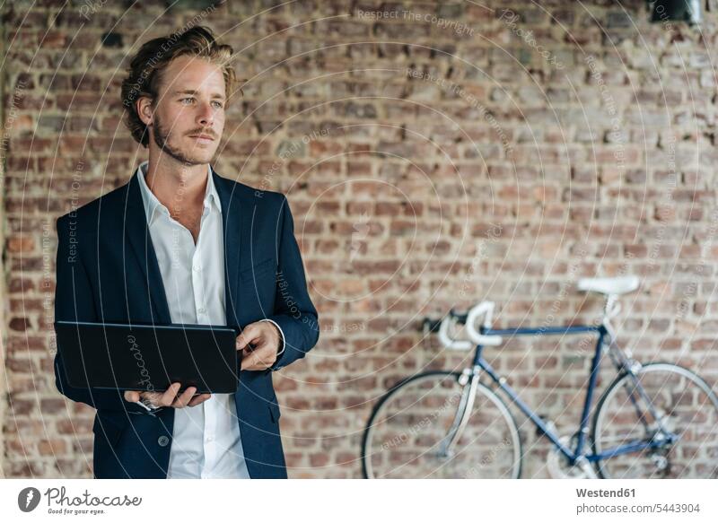 Businessman with laptop looking away men males Laptop Computers laptops notebook smiling smile thinking Adults grown-ups grownups adult people persons