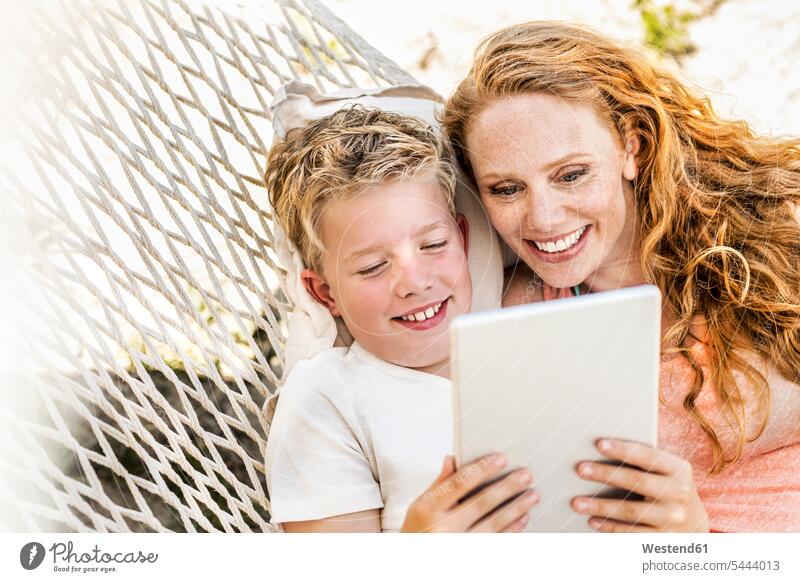 Happy mother and son lying in hammock looking at tablet hammocks digitizer Tablet Computer Tablet PC Tablet Computers iPad Digital Tablet digital tablets mommy