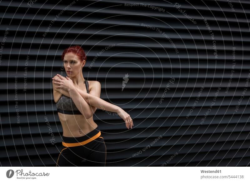 Young athlete stretching outdoors bare midriff bare stomach young woman females women workout working out work out fit warming up warm up practicing practice