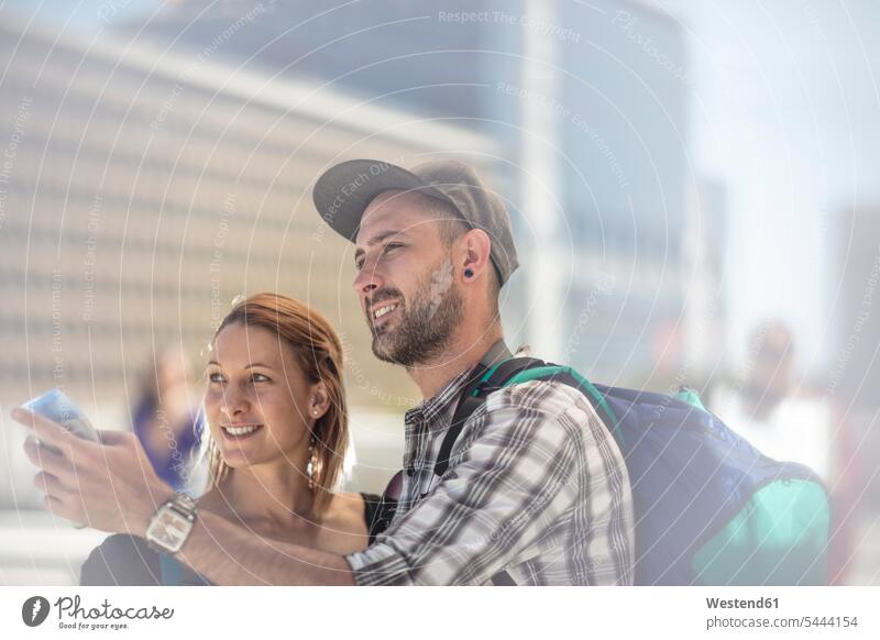 Backpacker couple searching for directions in the city tourist tourists twosomes partnership couples tourism touristic people persons human being humans