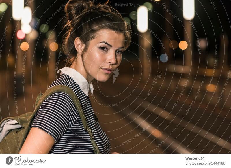 Portrait of young woman with backpack waiting at station by night females women at night nite night photography Adults grown-ups grownups adult people persons
