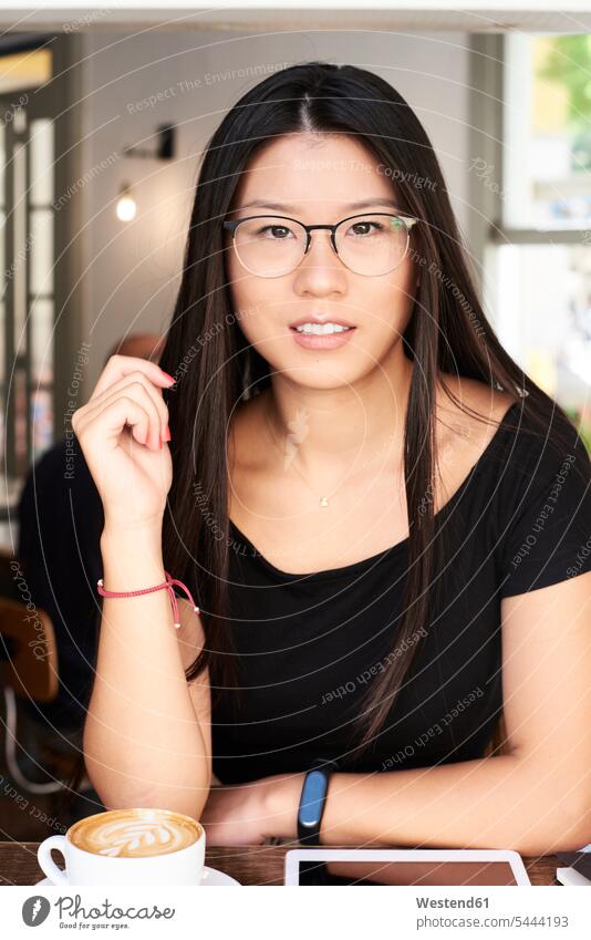 Portrait of an asian young woman looking at camera in a coffee shop portrait portraits smiling smile females women female Asian female Asians Cafe Shop cafe