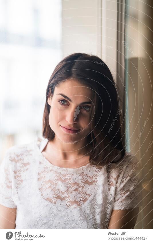 Smiling young woman sitting on bed looking at distance - a Royalty Free  Stock Photo from Photocase