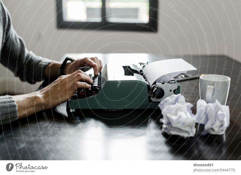 Close-up of man using typewriter with crumpled paper on desk typing typewriters men males desks Adults grown-ups grownups adult people persons human being