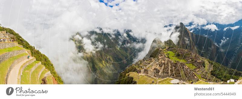 Peru, Andes, Urubamba Valley, Machu Picchu with mountain Huayna Picchu in fog with tourists valley valleys nature natural world Panorama UNESCO World Heritage