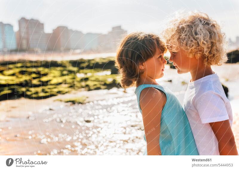 Little boy and girl face to face on the beach boys males females girls beaches child children kid kids people persons human being humans human beings friends