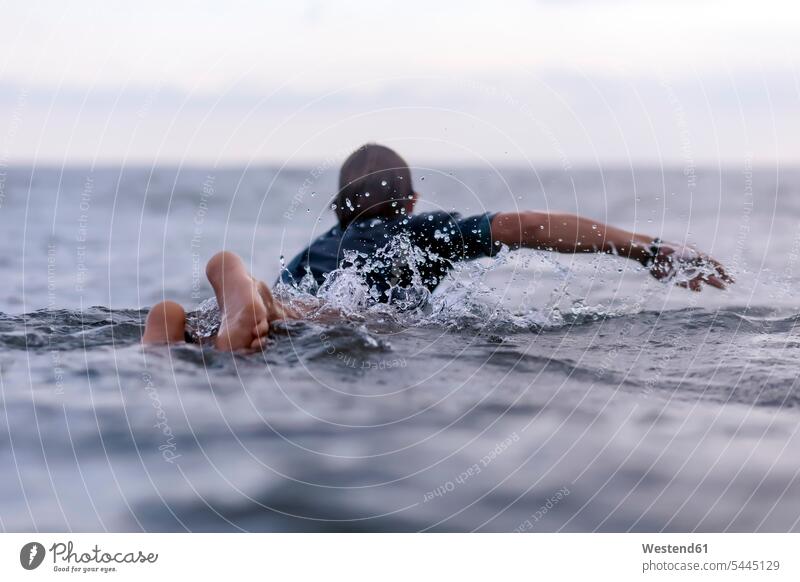 Back view of man on surfboard men males Sea ocean Adults grown-ups grownups adult people persons human being humans human beings water surfboards sportive