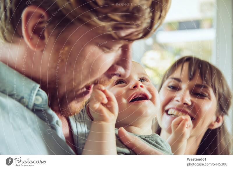 Happy couple with baby infants nurselings babies smiling smile twosomes partnership couples happiness happy people persons human being humans human beings