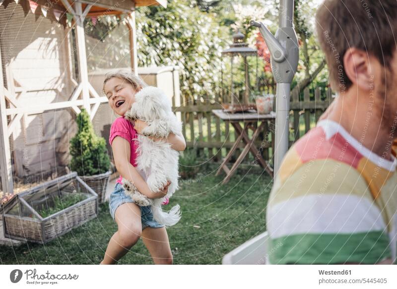Girl playing with dog in garden dogs Canine laughing Laughter happiness happy gardens domestic garden relaxed relaxation girl females girls pets animal