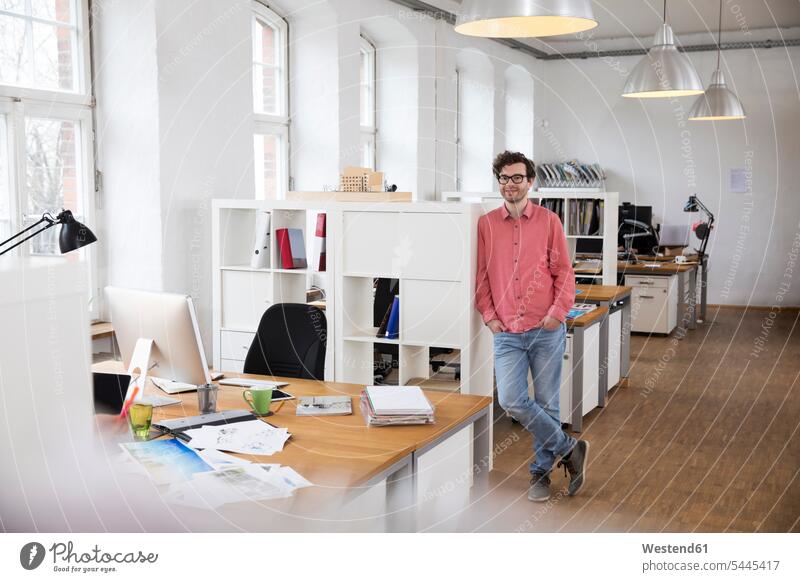 Portrait of confident man standing in office offices office room office rooms workplace work place place of work men males smiling smile Adults grown-ups