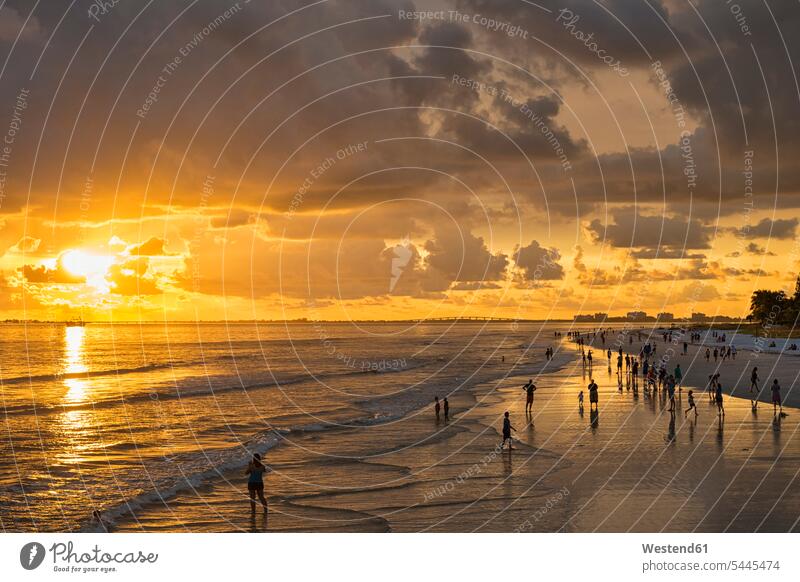 USA, Florida, Fort Myers, silhouettes of Fort Myers Beach and tourists with a huge rain cloud above during sunset coast coastline coast area Seacoast seaside