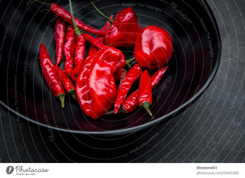 Black bowl of various red chili pods gleaming chili pepper hot pepper peppers Red Peppers hot peppers chili peppers Bowl Bowls Variety diversity Diverse varied