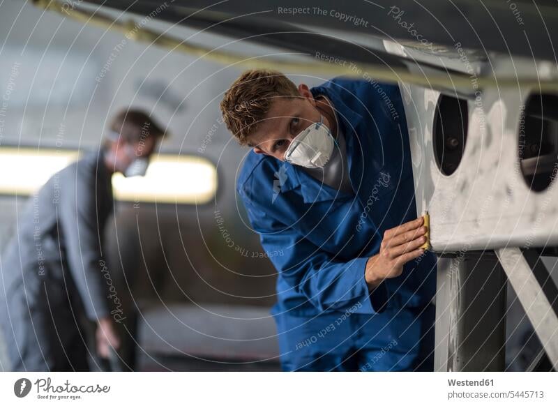 Industrial worker checking smoothness of metal while wearing protective mask working At Work man men males Adults grown-ups grownups adult people persons