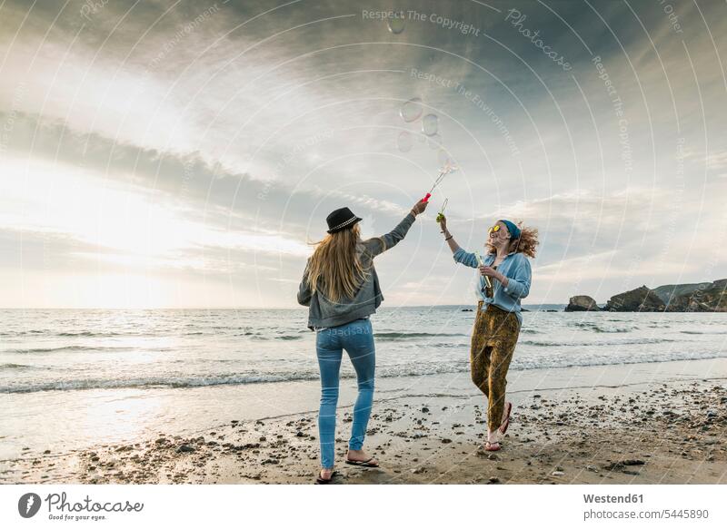 Happy friends making soap bubbles on the beach beaches happiness happy female friends mate friendship vacation Holidays Travel enjoying indulgence enjoyment