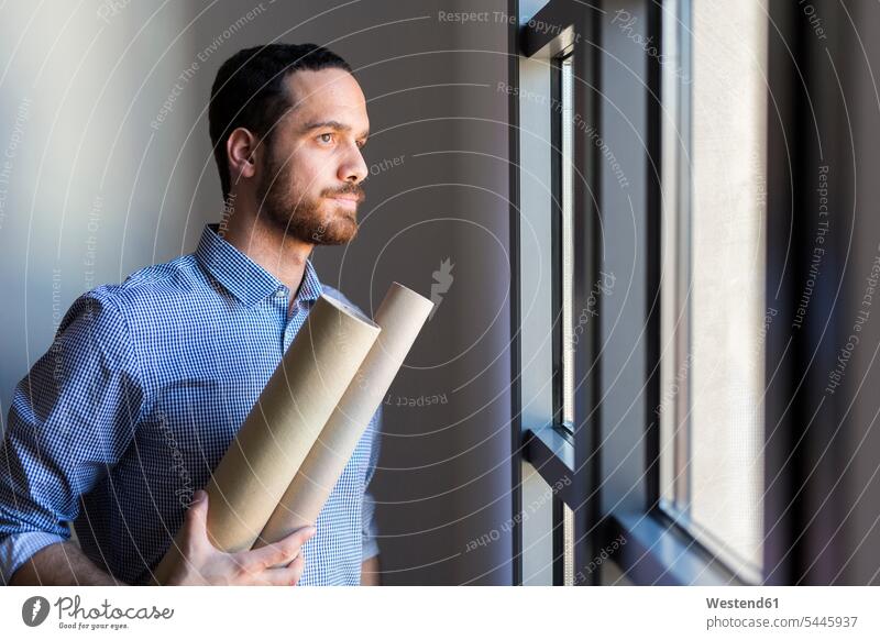 Architect looking out of window windows architect architects thinking occupation profession professional occupation jobs Job Occupation Work young man young men