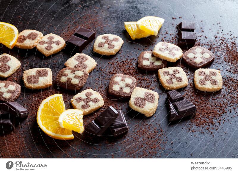 Black and white short crust Christmas cookies with orange slices and dark chocolate overhead view from above top view Overhead Overhead Shot View From Above