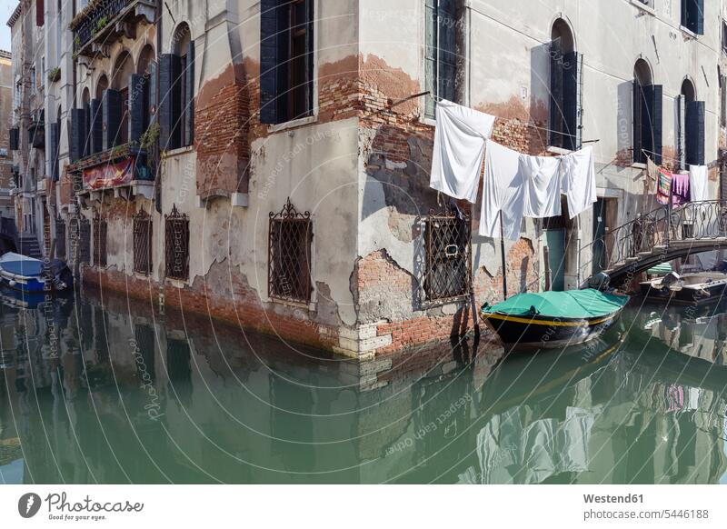 Italy, Venice, boat on canal and laundry at house window windows Run Down disrepair rundown Run-Down outdoors outdoor shots location shot location shots