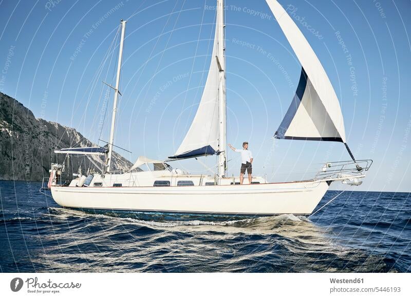 Mature man standing on his sailing boat looking at distance men males boat sports Adults grown-ups grownups adult people persons human being humans human beings