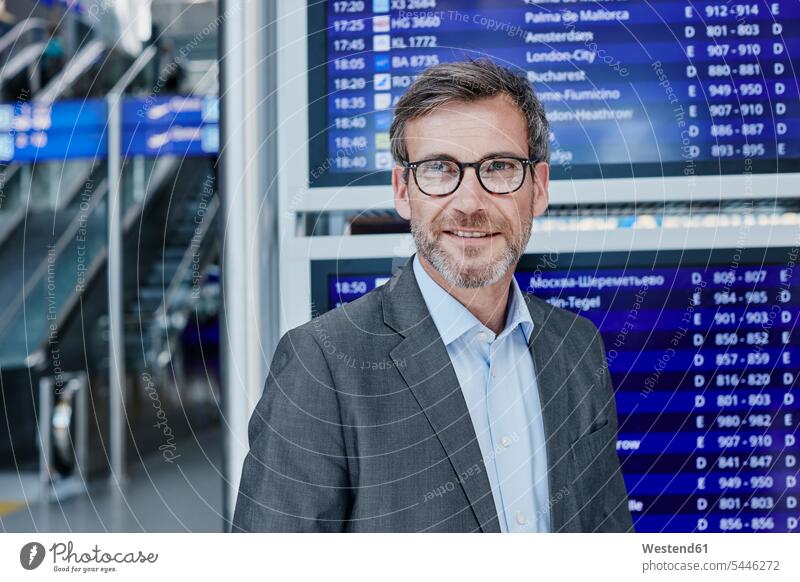 Smiling businessman at timetable at the airport Businessman Business man Businessmen Business men smiling smile terminal airports business people businesspeople