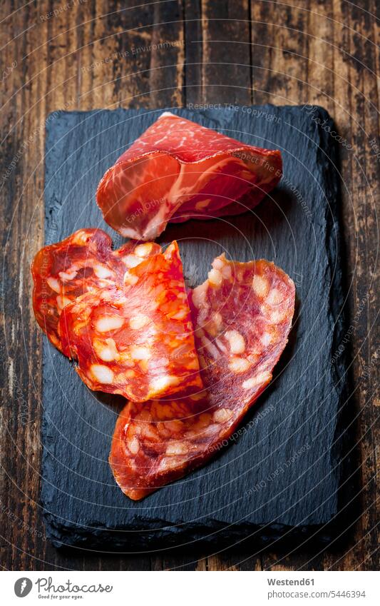 Slices of Spanish salami and slice of Italian ham on slate red wooden delicacy specialty specialties Italian Food Italian cuisine air-dried air-dry cold cuts