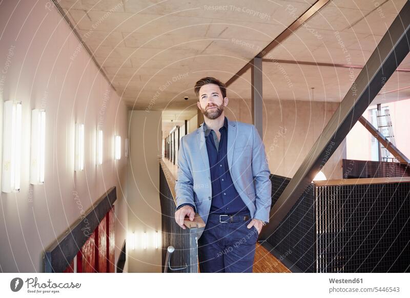 Businessman standing on office floor thinking Business man Businessmen Business men business people businesspeople business world business life offices