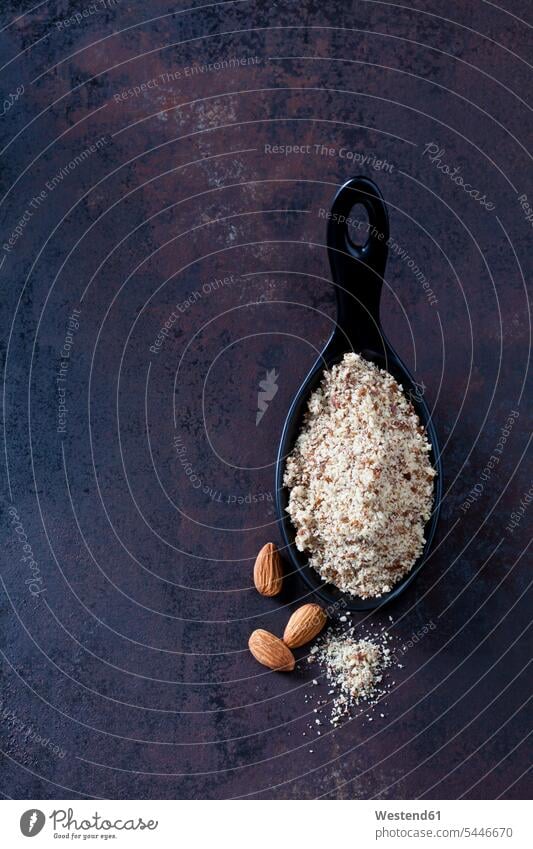 Spoon of almond flour and almonds on rusty ground copy space Almond Almonds overhead view from above top view Overhead Overhead Shot View From Above