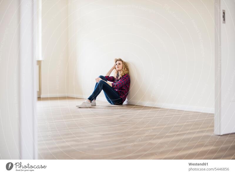 Young woman in new home sitting on floor females women Seated flat flats apartment apartments Adults grown-ups grownups adult people persons human being humans