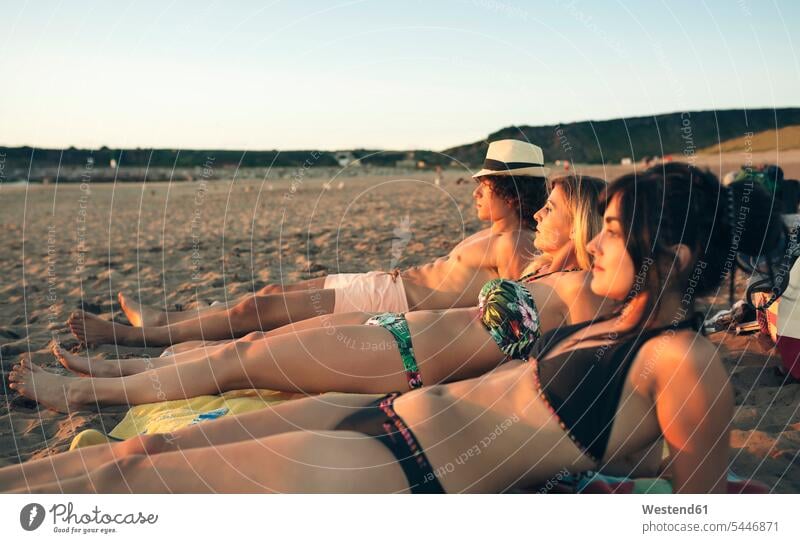 Friends relaxing on the beach beaches friends relaxed relaxation friendship lying laying down lie lying down vacation Holidays Travel thinking Summer Vacacion