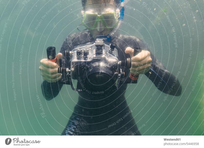 Man diving with underwater DSLR camera case dive cameras man men males diver divers Adults grown-ups grownups adult people persons human being humans