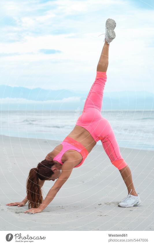 Woman practicing yoga on the beach exercising exercise training practising beaches fit sportive sporting sporty athletic woman females women practice practise