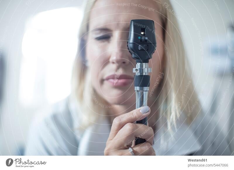 Female pedeatrician using a otoscope pediatrician paediatricians healthcare and medicine medical Healthcare And Medicines doctor physicians doctors caucasian