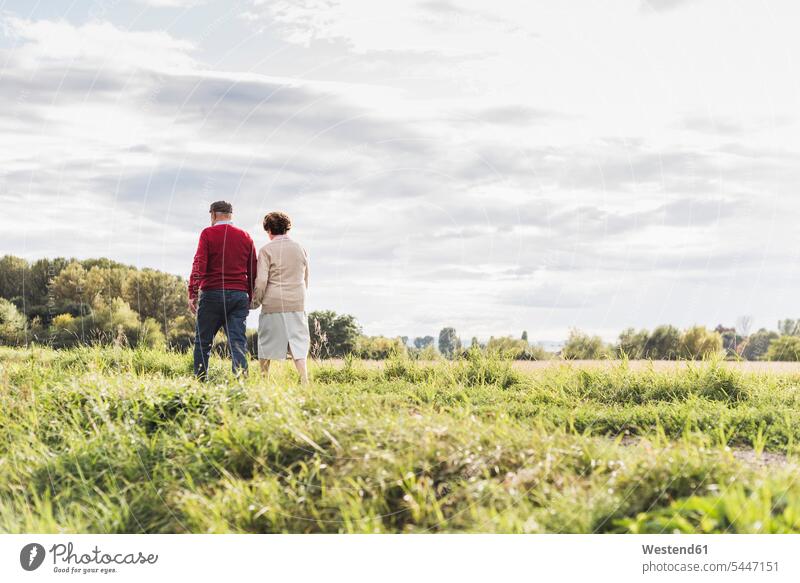 Senior couple on a walk in rural landscape twosomes partnership couples senior men senior man elder man elder men senior citizen walking going senior women