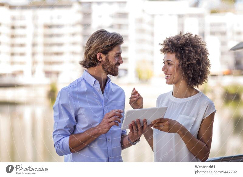 Businessman and woman having a meeting outdoors, using digital tablet colleagues digitizer Tablet Computer Tablet PC Tablet Computers iPad Digital Tablet