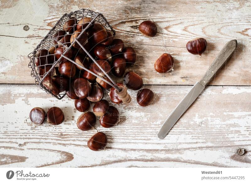 Sweet chestnuts in wire basket food and drink Nutrition Alimentation Food and Drinks large group of objects many objects wooden copy space collecting collected