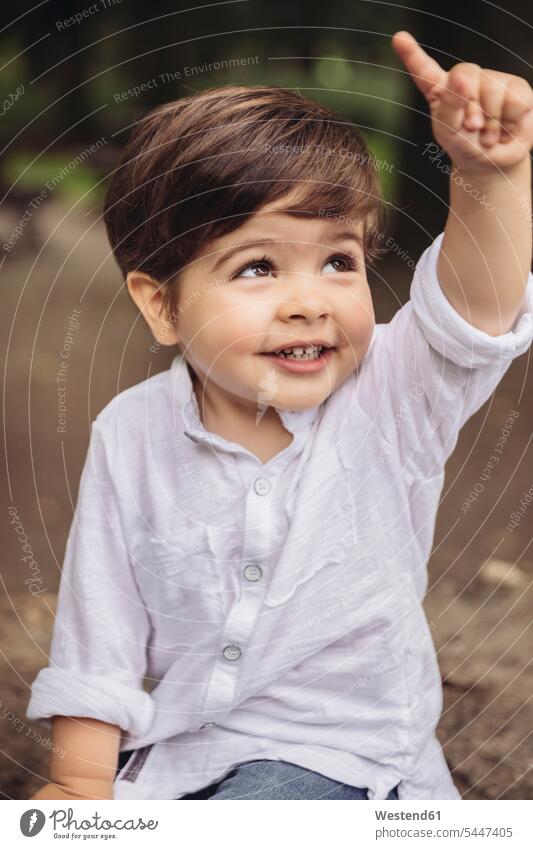 Portrait of smiling toddler raising his finger portrait portraits boy boys males child children kid kids people persons human being humans human beings smile