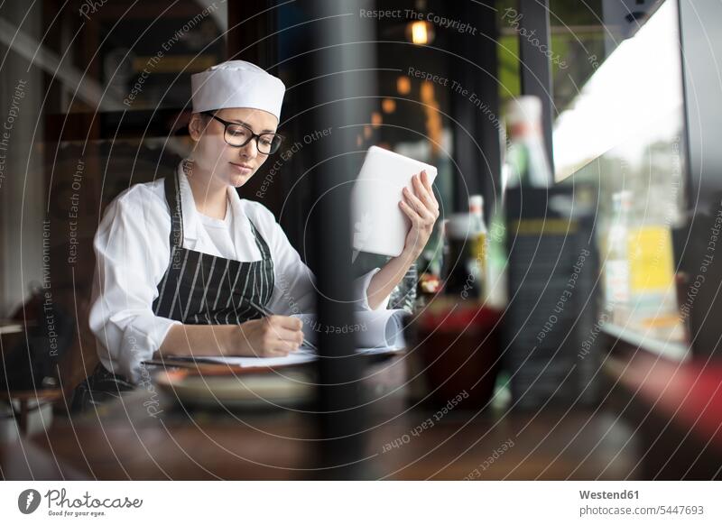 Woman in workwear with clipboard and tablet at the window clipboards clip-board clip-boards clip board working At Work woman females women digitizer