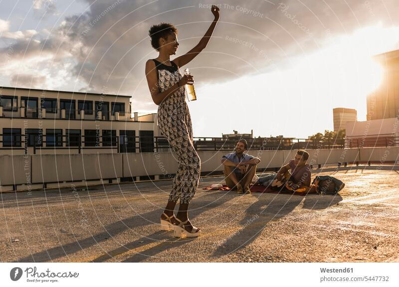 Young woman dancing on a rooftop party celebrating celebrate partying friends Fun having fun funny Party Parties dance laughing Laughter roof terrace deck