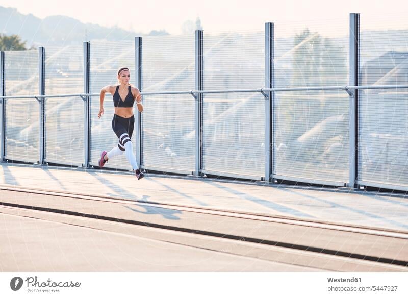 Young woman running in the city town cities towns females women outdoors outdoor shots location shot location shots Adults grown-ups grownups adult people