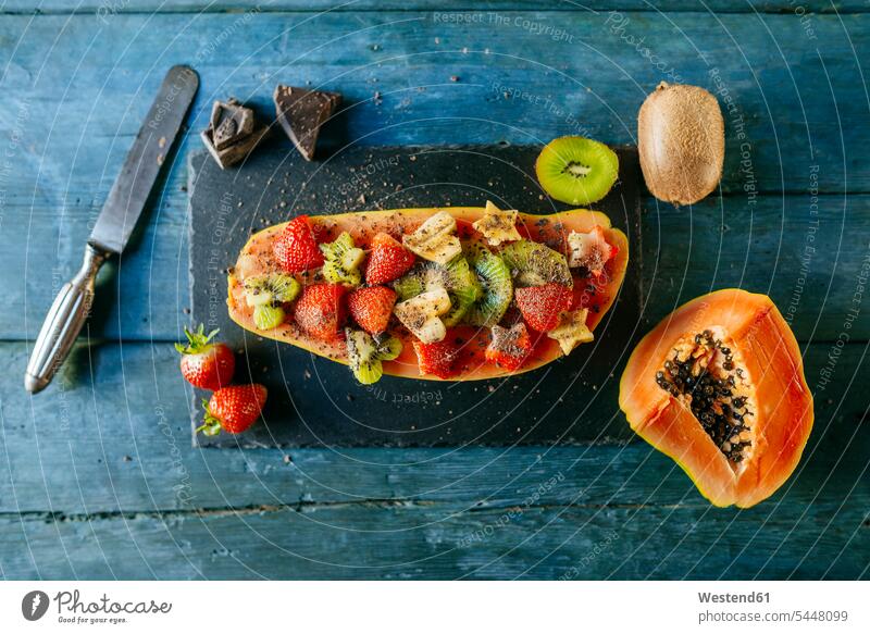 Half papaya decorated with pieces of banana, kiwi and strawberries on a plate of slate vitamines cut healthy eating nutrition Fruit Fruits Love loving blue