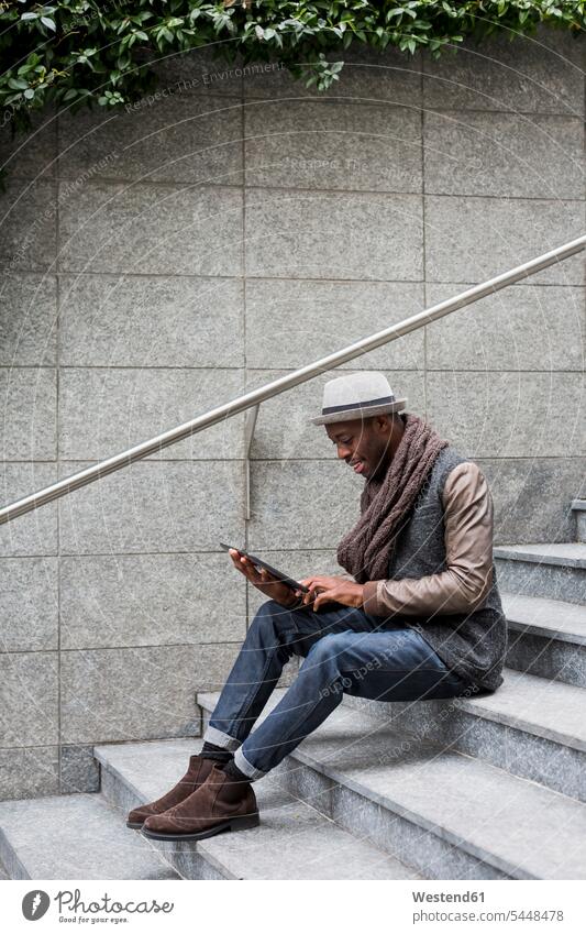 Man sitting on staircase using tablet stairs stairway digitizer Tablet Computer Tablet PC Tablet Computers iPad Digital Tablet digital tablets man men males