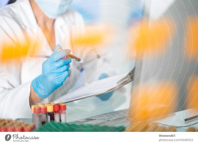 Close-up of lab technician examining test tubes with liquid in laboratory working At Work woman females women science sciences scientific Adults grown-ups