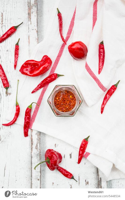 Glass of chili flakes and red chili pods on kitchen towel Glasses gleaming dried various different arrangement grouping dish towel Dishcloth tea towel