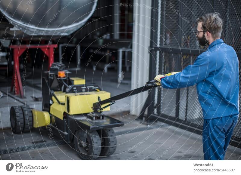 Worker pulling cart factory worker blue collar worker workers blue-collar worker man men males working At Work Job Occupation Adults grown-ups grownups adult