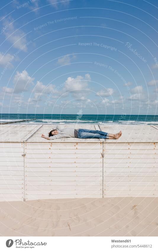 Woman lying on wooden box on the beach beaches woman females women laying down lie lying down relaxed relaxation Adults grown-ups grownups adult people persons