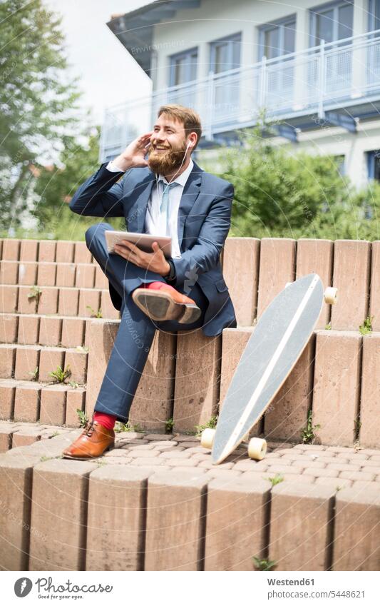 Businessman with skateboard, tablet and earphones on the phone Business man Businessmen Business men call telephoning On The Telephone calling business people