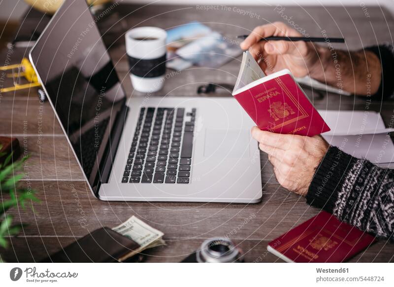 Man holding passport planning a trip Travel laptop Laptop Computers laptops notebook passports hand human hand hands human hands computer computers people