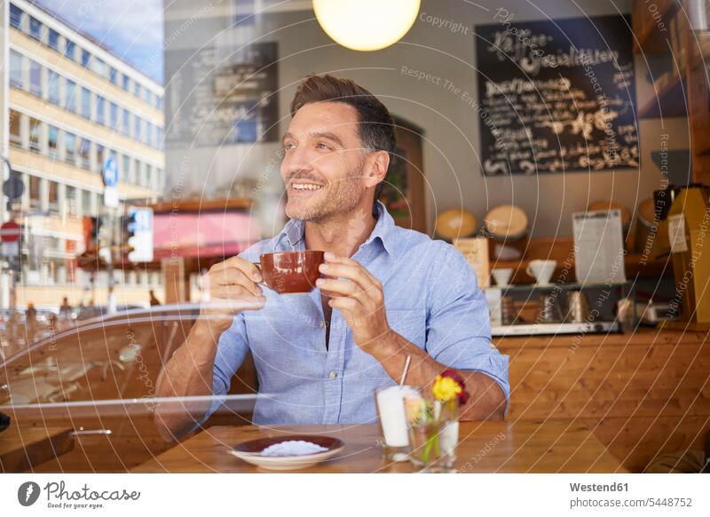 Portrait of laghing man with cup of coffee in a coffee shop Coffee cafe laughing Laughter windowpane window glass window glasses windowpanes Window Pane