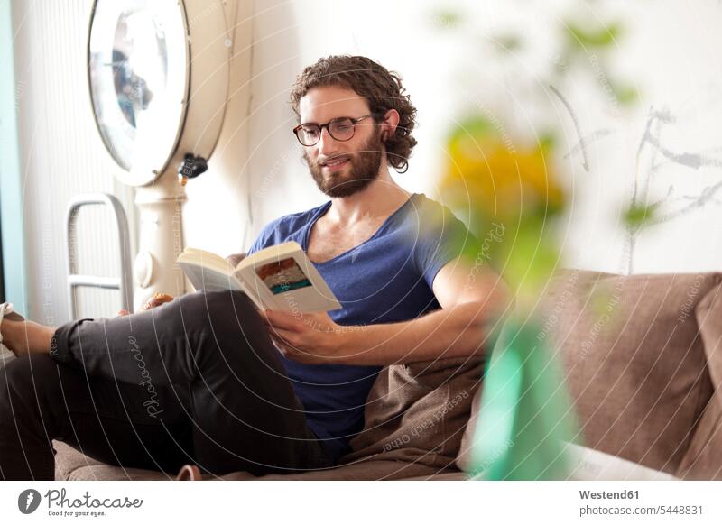 Portrait of smiling young man reading book in a coffee shop books men males Adults grown-ups grownups adult people persons human being humans human beings