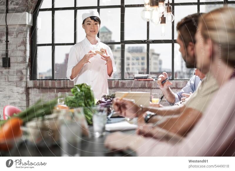 Female chef talking to students in cooking class speaking female cook group of people Group groups of people cooks Chefs persons human being humans human beings