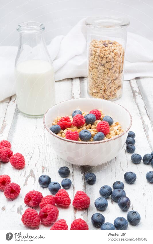 Bowl of granola with raspberries and blueberries food and drink Nutrition Alimentation Food and Drinks healthy eating nutrition Breakfast wooden